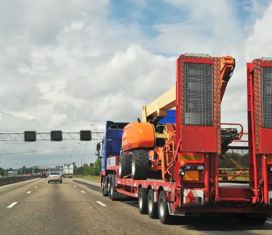 heavy construction equipment on flatbed for delivery
